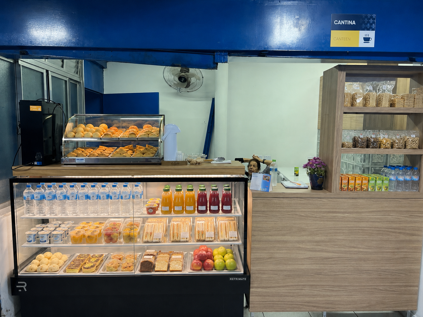 Balcão da cantina Delícias da Marinha no Colégio Mãe Admirável, com lanches, sucos e salgados